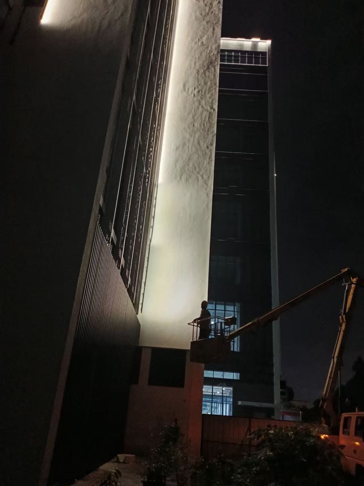 从高空作业平台进行夜间验证,安装灯具向外立面高处投射