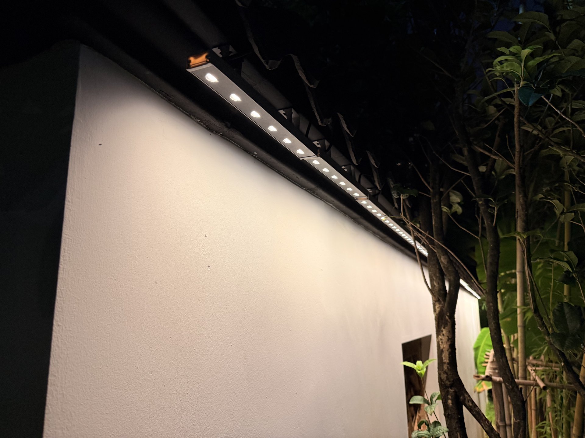 瓦檐下近距离安装的线性LED灯具照亮抹灰墙面