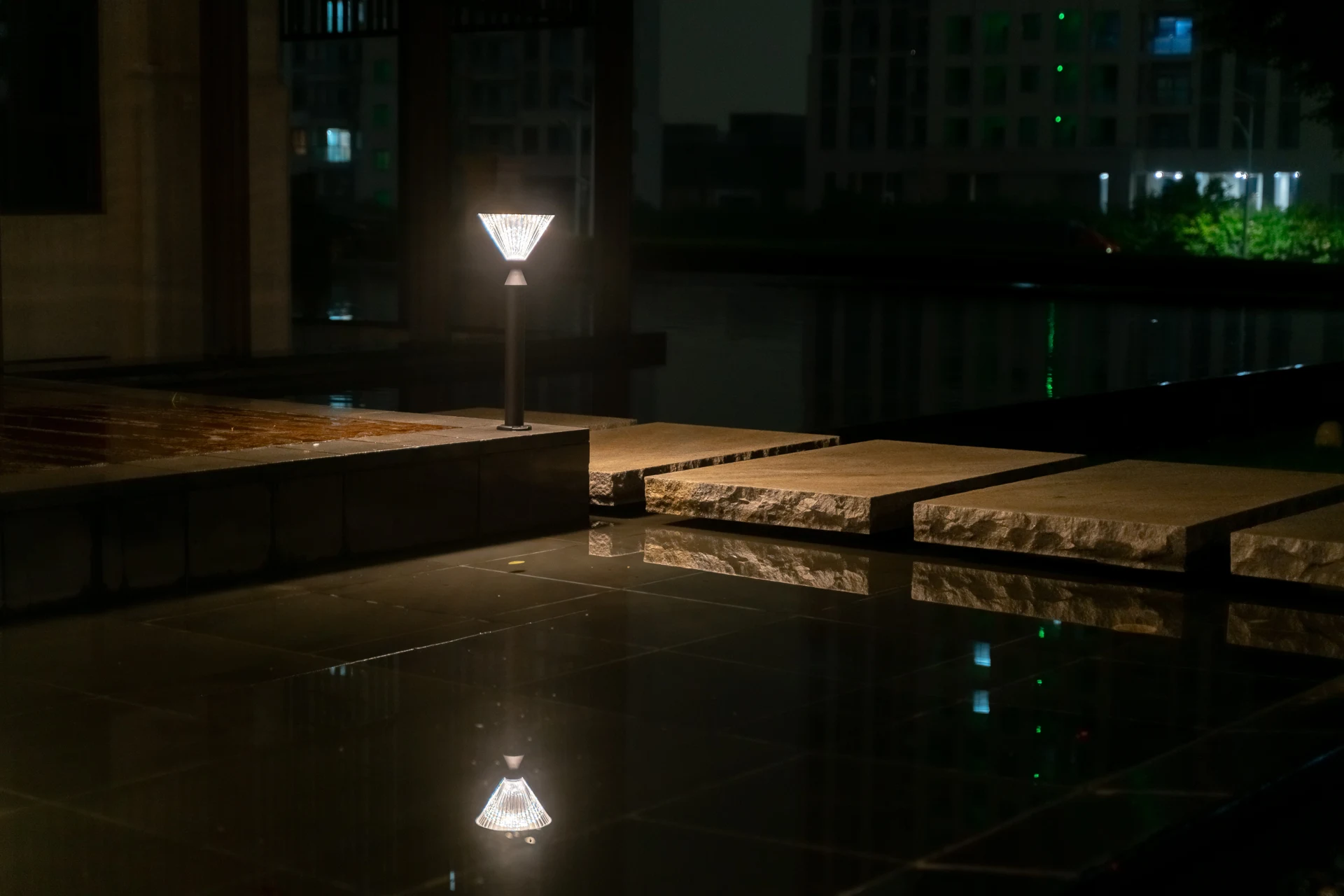 SGL-4505 solar bollard beside reflecting courtyard pool with water reflection