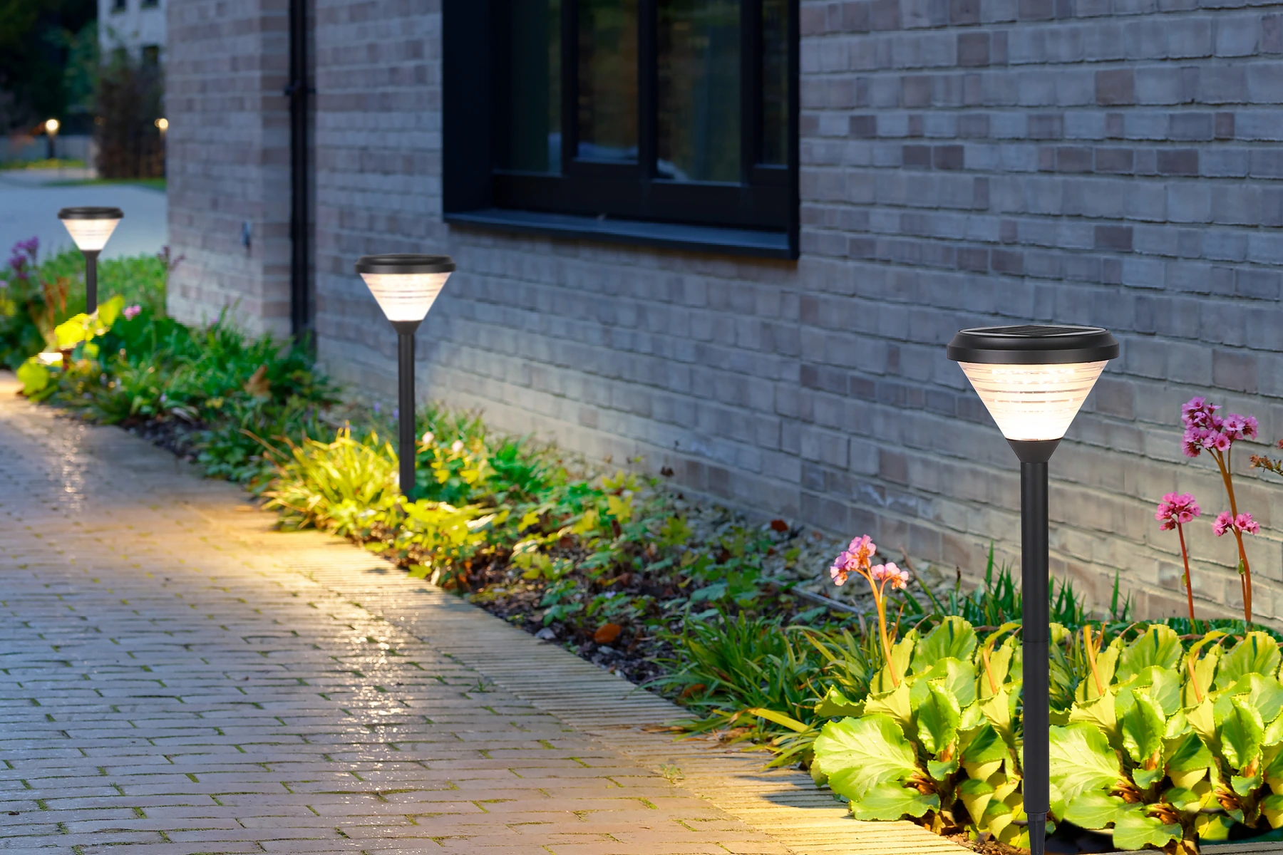 SLL-3004 hourglass solar bollards along paved pedestrian walkway