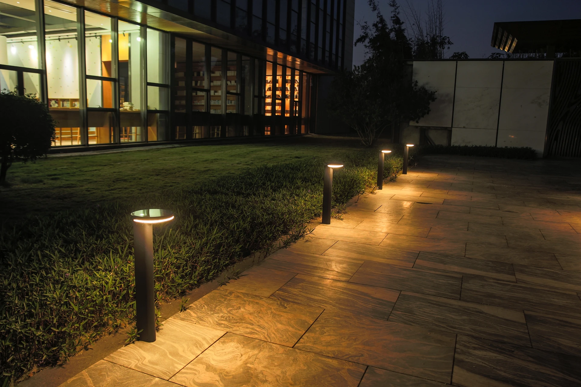 SLL-8804 solar bollard beside reflecting courtyard pool with water reflection