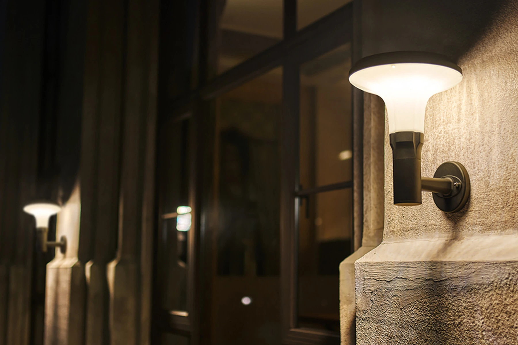 SWL-1004 jasmine solar wall lights mounted along villa stone facade at twilight