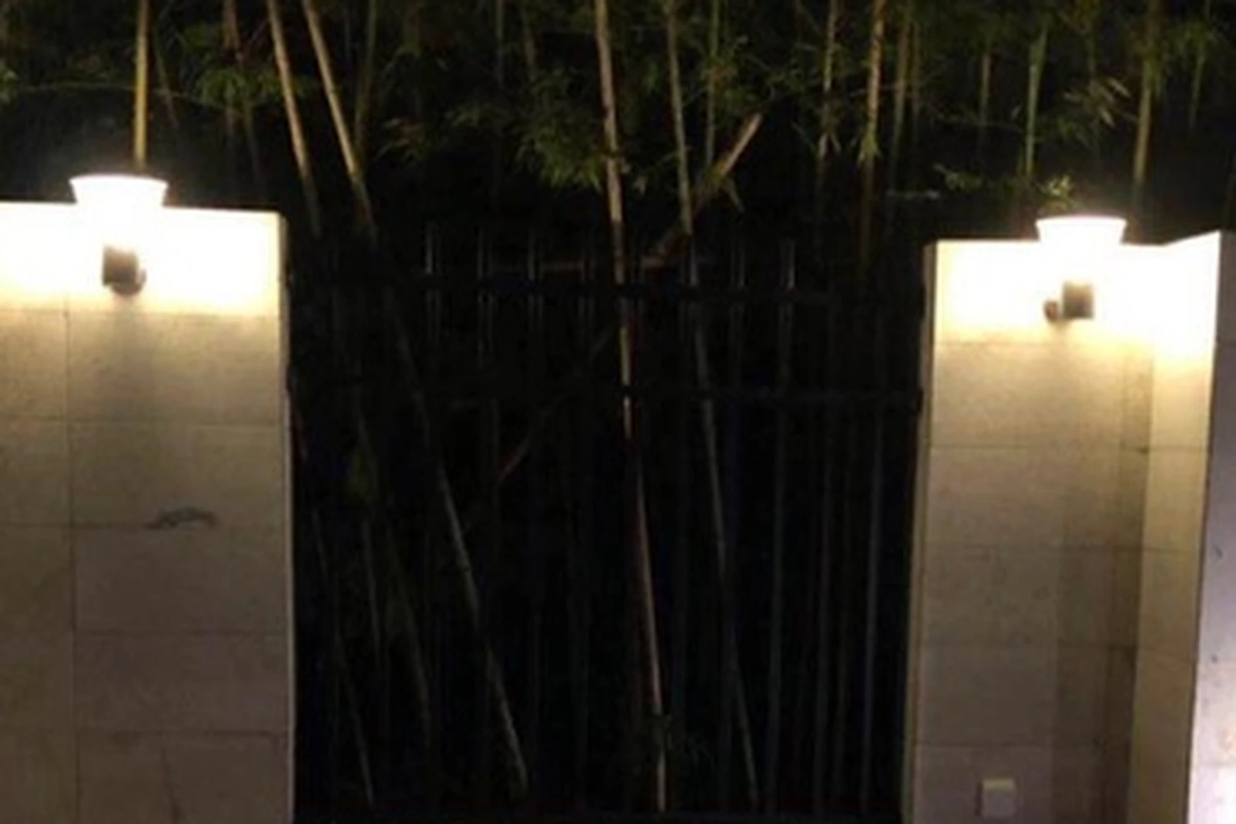 SWL-4001 wall lights installed along stone courtyard entry walls and bamboo fencing