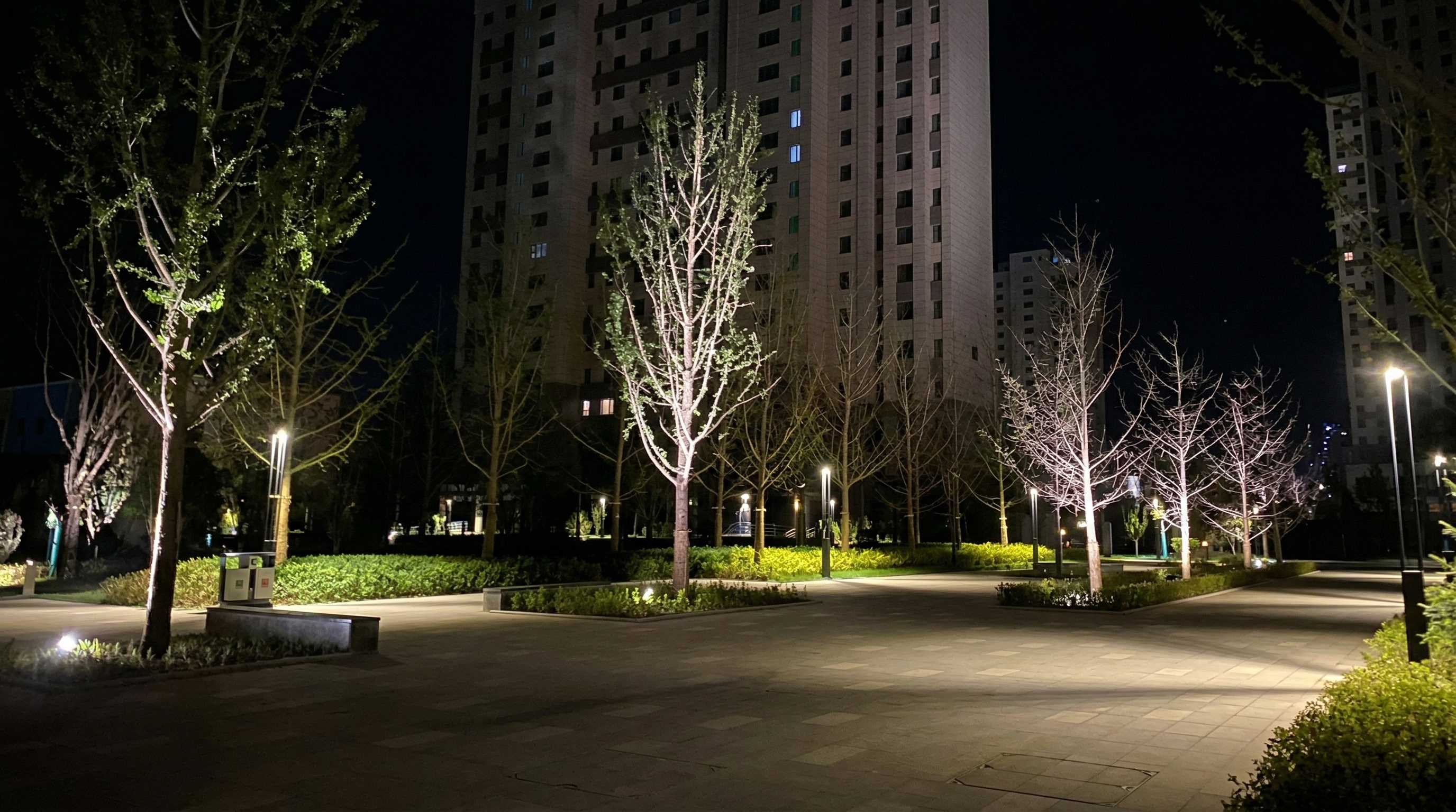LED in-ground lamps illuminating pedestrian pathways and modern commercial architecture