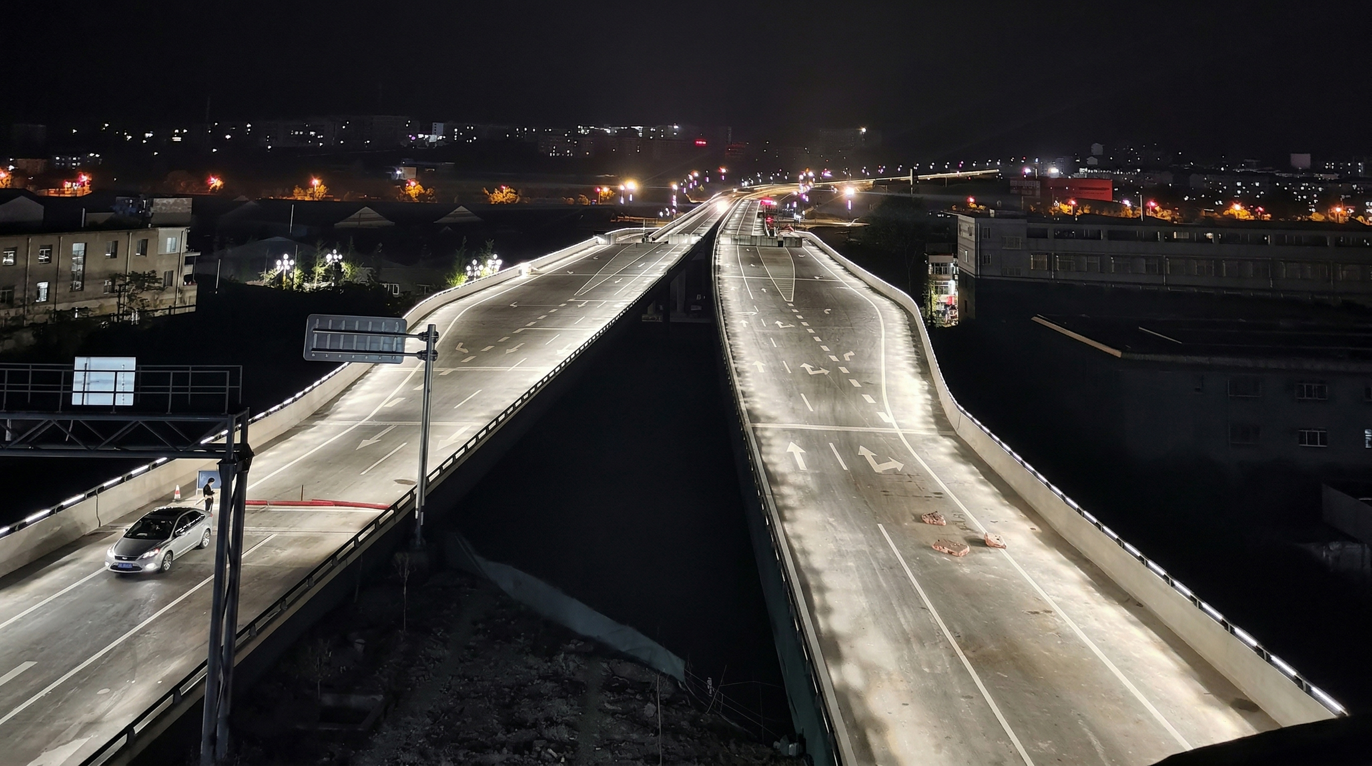 Structural floodlights accentuating overpass vertical piers and geometric architectural forms