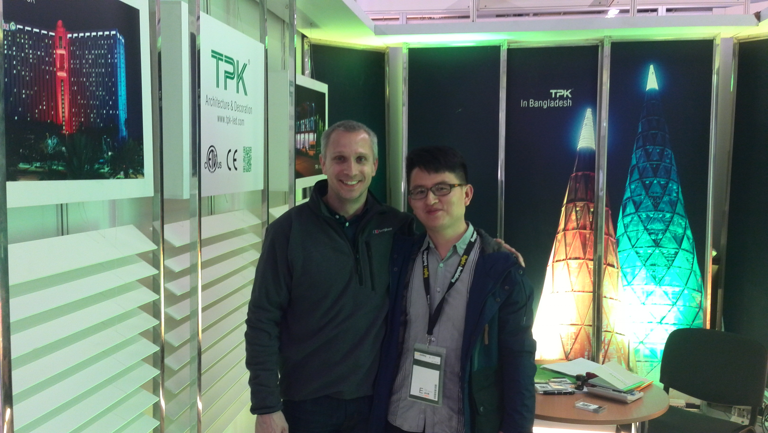 Visitors at the TPK booth reviewing linear lights.